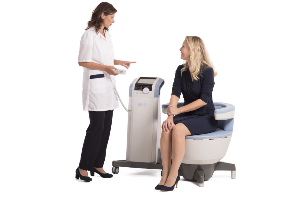 Emsella chair with a patient sitting comfortably and clinician standing beside them Miramont Wellness Centers
